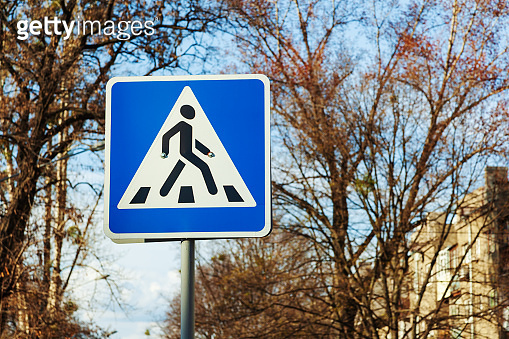 Pedestrian crossing sign on trees and city buildings background. 이미지 ...