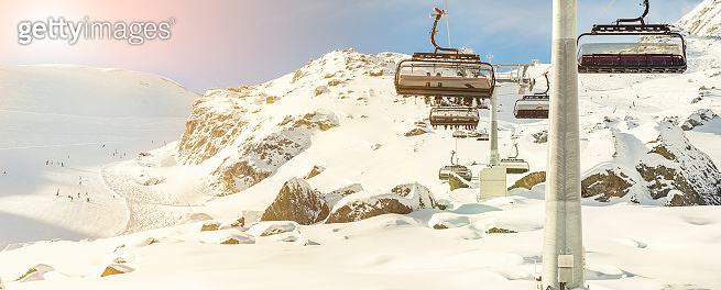Ski lift ropeway on hilghland alpine mountain winter resort on bright ...