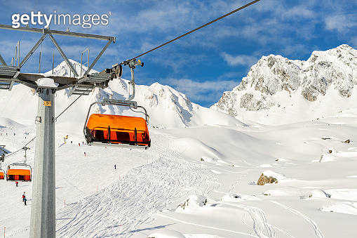 Ski lift ropeway on hilghland alpine mountain winter resort on bright ...