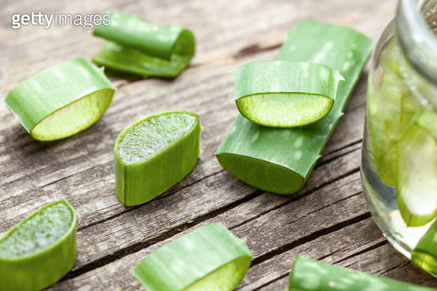 Aloe Vera gel cream for skin and body care. Aloe pulp slices in a glass ...