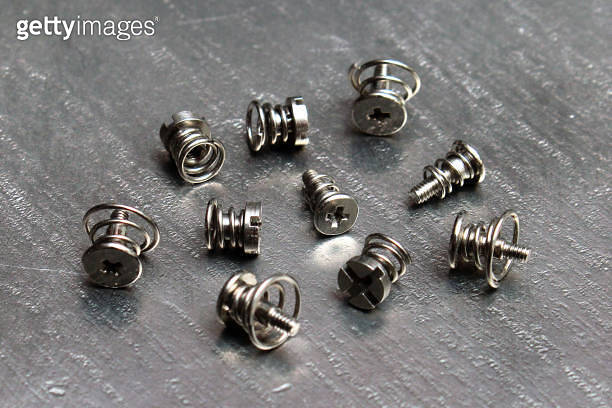 Spring loaded screws on steel metal background 이미지 (1187341589) - 게티이미지뱅크