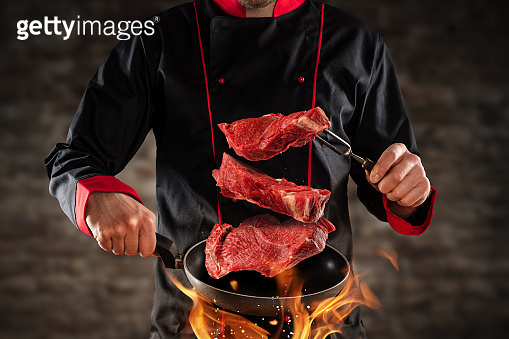 Closeup of chef throwing raw beef steaks (1138483539) - 게티이미지뱅크