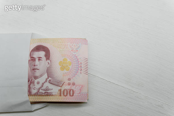 Thai Banknote 100 Baht In A White Envelope On A White Table Concept Of thai-banknote-100-baht-in-a-white-envelope-on-a-white-table-concept-of