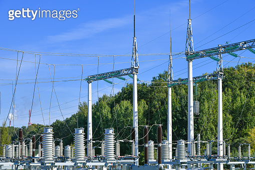 High voltage electricity pylons against perfect blue sky with white ...