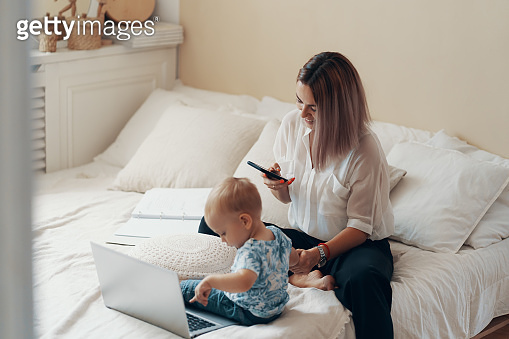 Modern woman working with child. Multi-tasking, freelance and ...