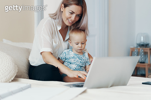 Modern woman working with child. Multi-tasking, freelance and ...
