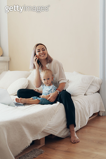 Modern woman working with child. Multi-tasking, freelance and ...