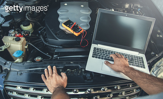 man to repair car with hand computer (1197283024) - 게티이미지뱅크