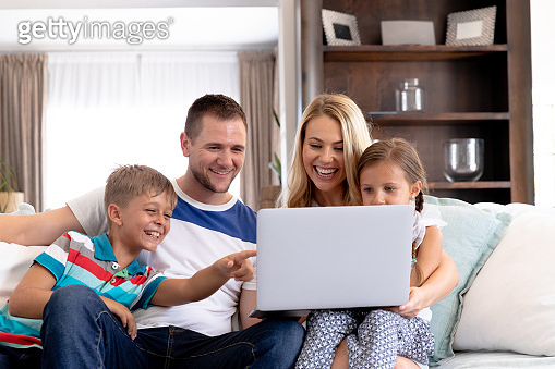 Caucasian family with two children using a laptop computer at home 이미지 ...