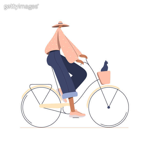 Happy girl dressed in trendy clothes riding bicycle with cat in front