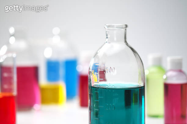 Glass bottles and flasks of different sizes with liquids of different ...