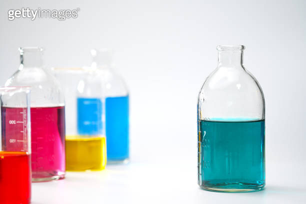 Glass bottles and flasks of different sizes with liquids of different ...