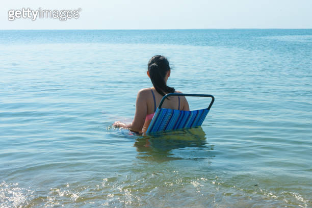 Young woman relaxing on beach chair in the water. Summer concept. girl ...