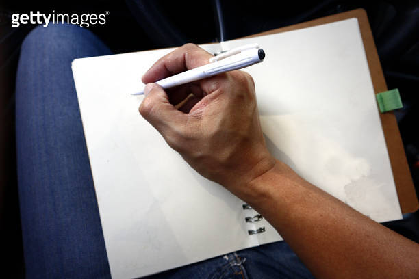 Hand writing with a pen on a notebook while inside a car 이미지 ...