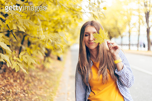 Portrait of happy cheerful woman with a smile holds an autumn yellow ...