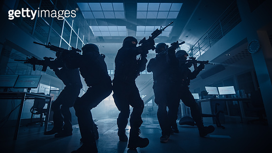 Masked Team of Armed SWAT Police Officers Move in a Hall of a Dark ...