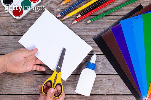 Child Getting Paper The child holds a paper strip square and cuts it. The child makes ...