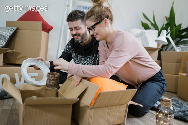 Young couple unpacking boxes in their new home 이미지 (1292057924) - 게티이미지뱅크