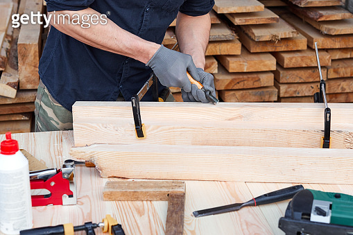 Male carpenter hands using instrument or equipment on a wooden table ...
