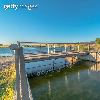 Square frame Bridge over lake with lakefront buildings and mountain ...