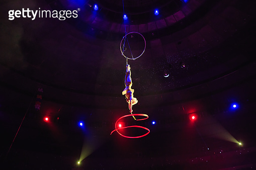 Aerial acrobat in the ring. A young girl performs the acrobatic ...