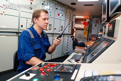 Marine engineer officer controlling vessel engines and propulsion in ...