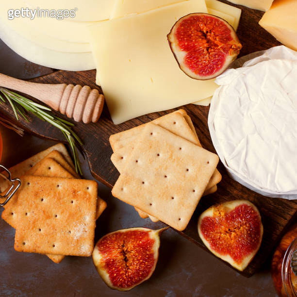 Cheese board with brie, maasdam, gouda and goat cheese, figs, honey and