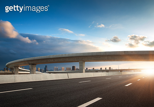 The clear sky in the evening, the curved approach bridge of the highway ...