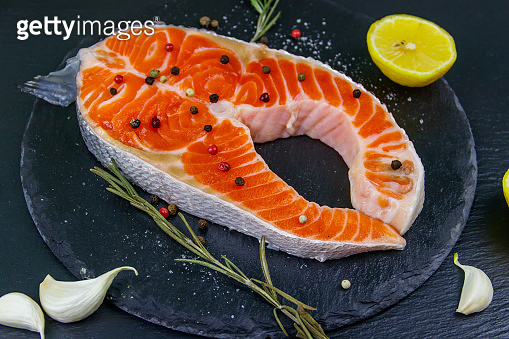 Raw salmon steak with spices on black slate 이미지 (1249961367) - 게티이미지뱅크