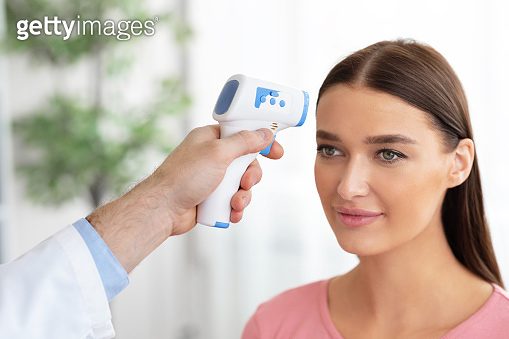 Doctor checking temperature of patient using infrared thermometer 이미지 ...