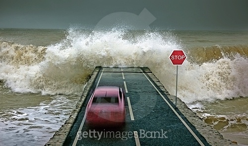car rushing along the highway towards the giant wave (a10872052) - 게티이미지뱅크