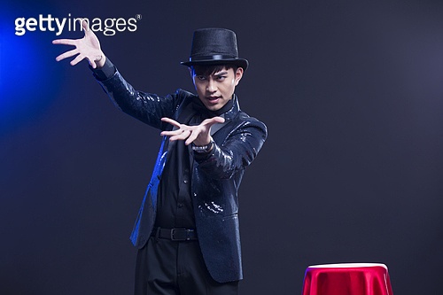 Young Chinese magician performing magic trick 이미지 (a11095488) - 게티이미지뱅크
