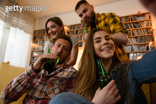 Friends hanging out together on a house party taking selfie with a ...