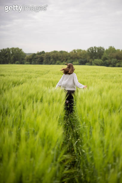 Relaxed woman standing in green field and enjoys calm nature 이미지 ...