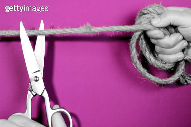 Hand with scissors cutting rope that ties woman 이미지 (1306024185) - 게티이미지뱅크