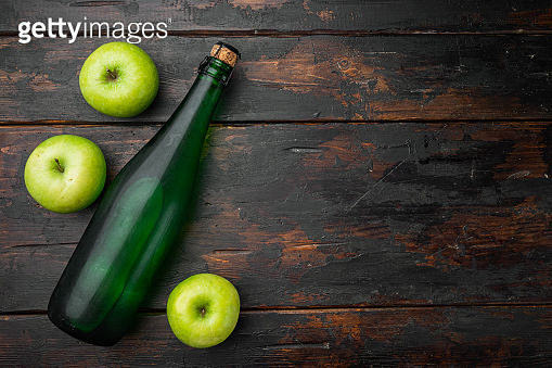 Apple cider bottle, on old dark wooden table background, top view flat