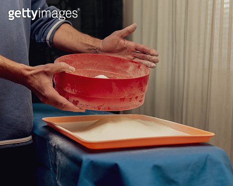 A man sows flour through a sieve. (1321162356) - 게티이미지뱅크
