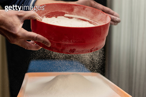 A man sows flour through a sieve. (1321162367) - 게티이미지뱅크