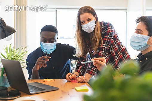 People wearing face mask at work in small home office - New working ...