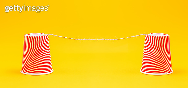 Two red paper cups connected by a rope. Children's homemade toy-walkie ...
