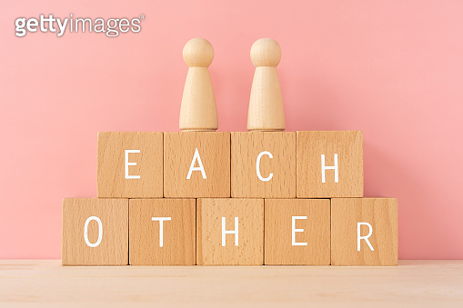 Each other; Wooden blocks with "EACH OTHER" text of concept and human ...