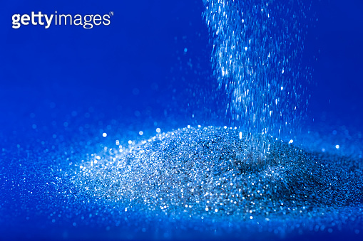 Sparkling blue glitter powder sprinkled on a black background 이미지 ...