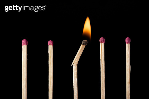 Falling Matches One broken burning match in line with other ordinary unignited matches ...