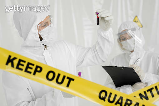 Epidemiologist woman in protective clothing is in a restricted area ...