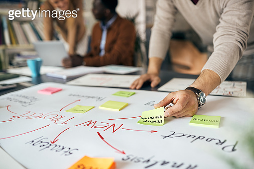 Close-up of businessman creating mind map on paperboard while working ...