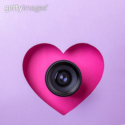 Pink Heart Camera Pink heart on a purple background. At the heart is a camera lens ...