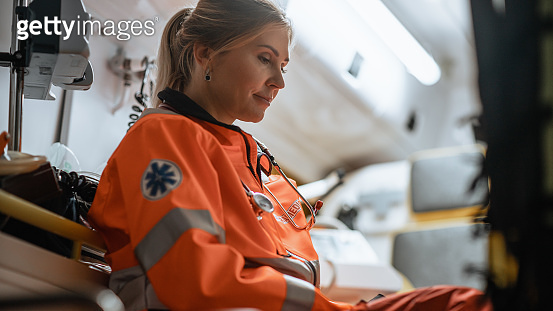 Tired Female EMS Professional Paramedic Tries to Rest in an Ambulance ...