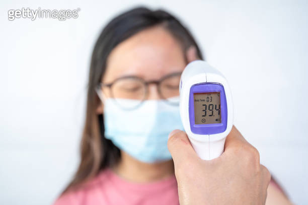 Someone hand using infrared thermometer gun to measuring woman ...