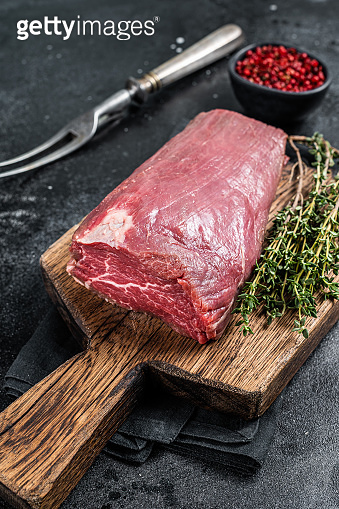 Raw Beef Tenderloin fillet meat on butcher wooden board. Black ...