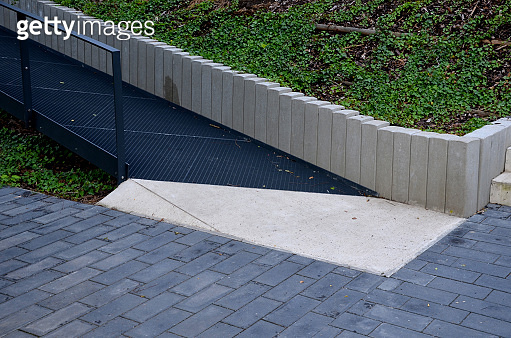 ramp combined with a staircase made of gray concrete and a railing ...